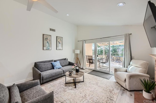 living room with light hardwood / wood-style floors, ceiling fan, and vaulted ceiling