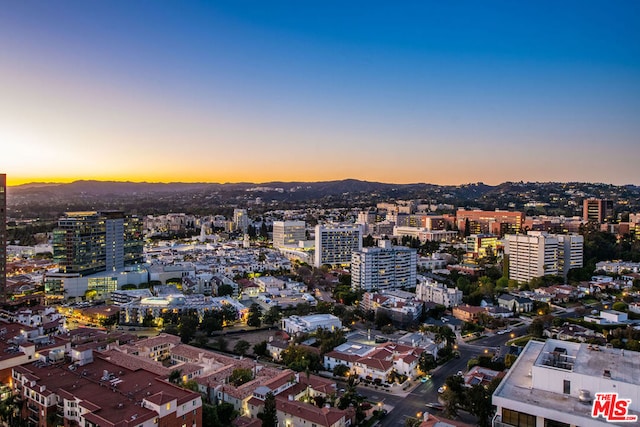 aerial view at dusk featuring a mountain view