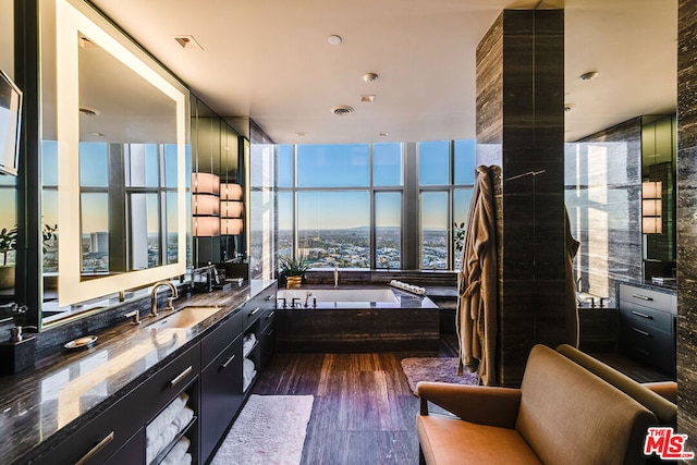 bathroom featuring hardwood / wood-style flooring, vanity, and a washtub