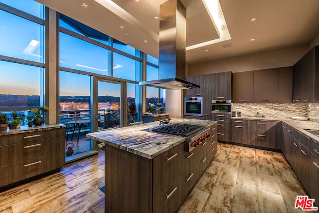 kitchen with a center island, light hardwood / wood-style flooring, appliances with stainless steel finishes, island range hood, and light stone counters