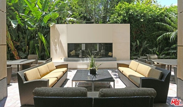 view of patio featuring an outdoor living space with a fireplace