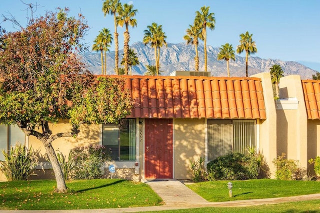 view of front of home featuring a mountain view and a front lawn