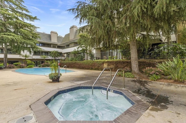 view of swimming pool with a hot tub