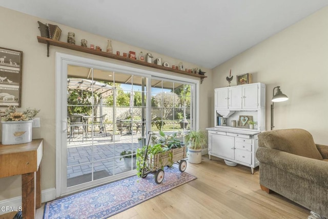 entryway with vaulted ceiling and light hardwood / wood-style flooring