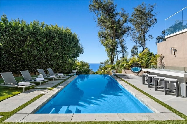 view of swimming pool with a patio area and exterior bar