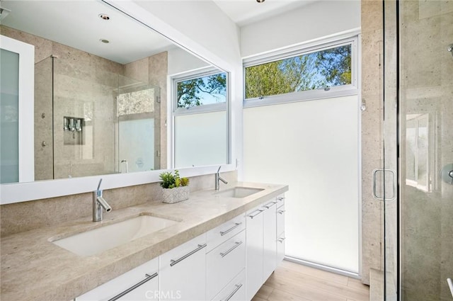 bathroom featuring a shower with shower door, vanity, and hardwood / wood-style flooring