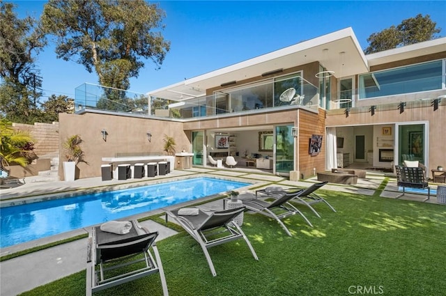 back of house with a lawn, a balcony, and a patio