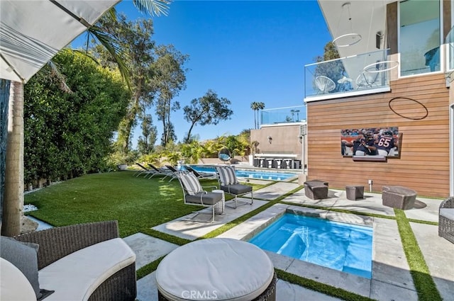 view of pool featuring a hot tub, a lawn, and a patio