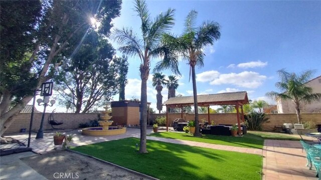 view of property's community featuring a lawn, a gazebo, and a patio area