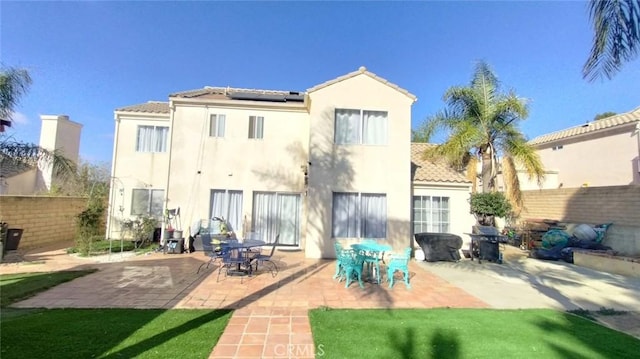 back of house with a patio area and solar panels