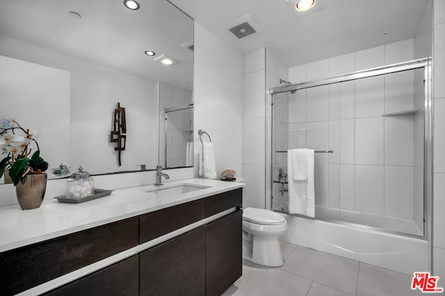 full bathroom with toilet, enclosed tub / shower combo, tile patterned flooring, and vanity