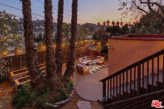 deck at dusk featuring outdoor lounge area