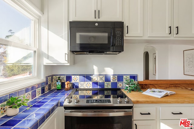 kitchen with white cabinetry, tile countertops, and electric range