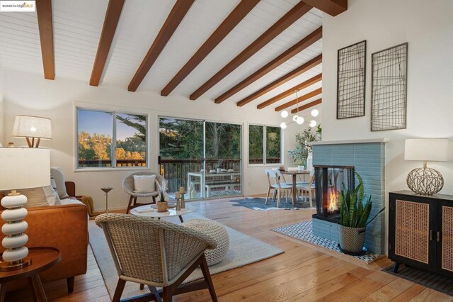 living room featuring beam ceiling, high vaulted ceiling, a fireplace, and hardwood / wood-style flooring