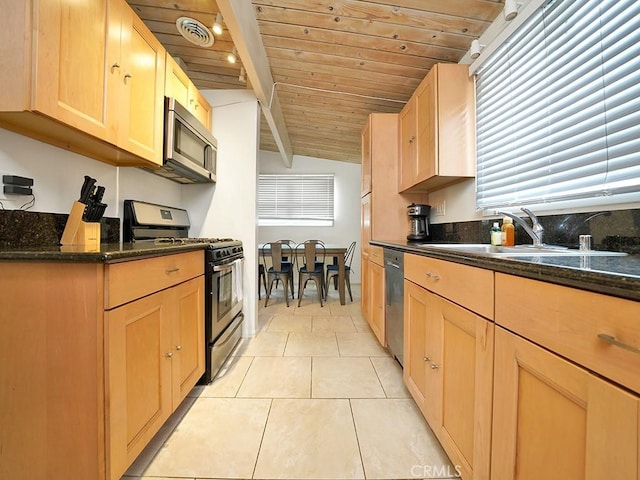 kitchen featuring lofted ceiling with beams, sink, stainless steel appliances, dark stone counters, and wooden ceiling