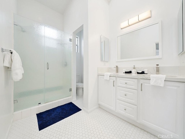 bathroom with an enclosed shower, vanity, tile patterned flooring, and toilet