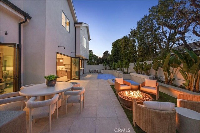 patio terrace at dusk featuring a fire pit