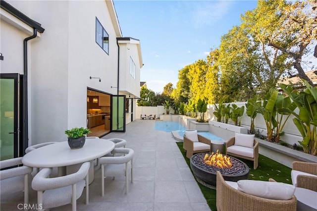 view of patio featuring an outdoor living space with a fire pit