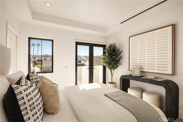 bedroom with access to outside, wooden ceiling, french doors, and a raised ceiling