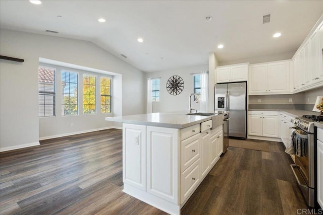 kitchen with sink, white cabinetry, appliances with stainless steel finishes, and a center island with sink