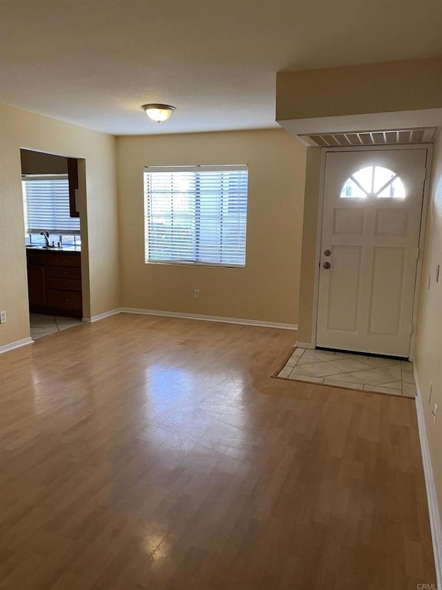 entryway with sink and light hardwood / wood-style floors