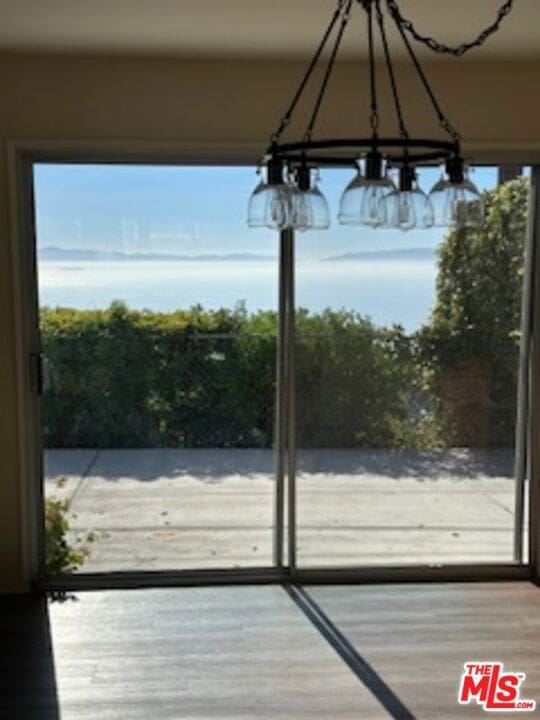 doorway to outside with a chandelier and hardwood / wood-style floors