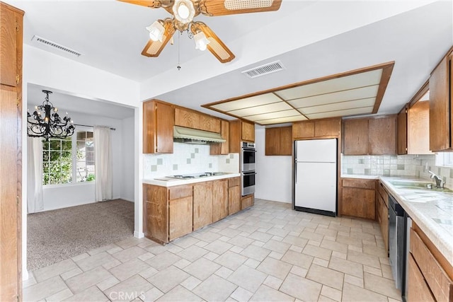 kitchen featuring appliances with stainless steel finishes, light colored carpet, tasteful backsplash, and sink