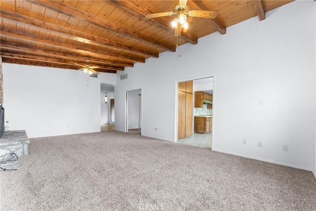 unfurnished living room with ceiling fan, wooden ceiling, light colored carpet, and beam ceiling