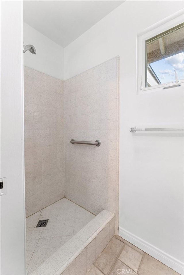 bathroom featuring tile patterned flooring and tiled shower