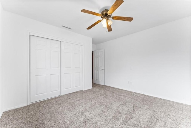 unfurnished bedroom with ceiling fan, a closet, and carpet flooring