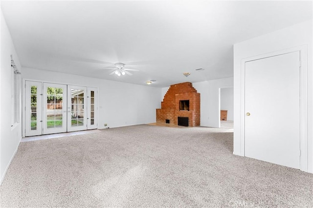 unfurnished living room featuring ceiling fan and a fireplace