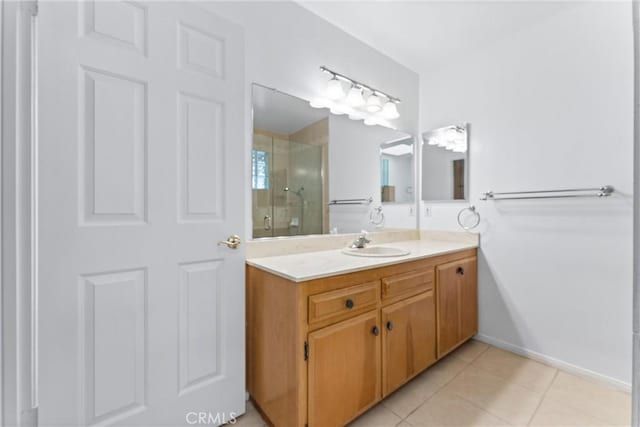 bathroom featuring a shower with shower door, vanity, and tile patterned flooring