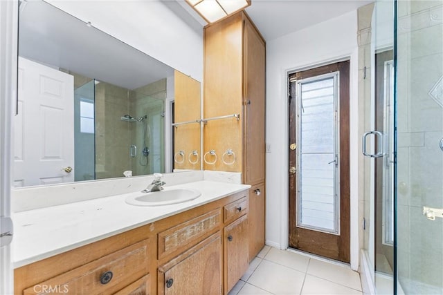 bathroom with walk in shower, vanity, and tile patterned flooring