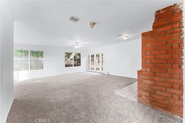 spare room with light carpet, ceiling fan, and french doors