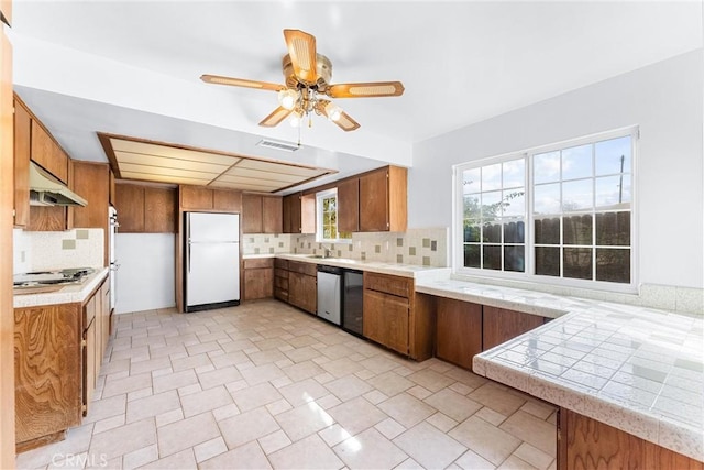 kitchen with decorative backsplash, sink, appliances with stainless steel finishes, and ceiling fan