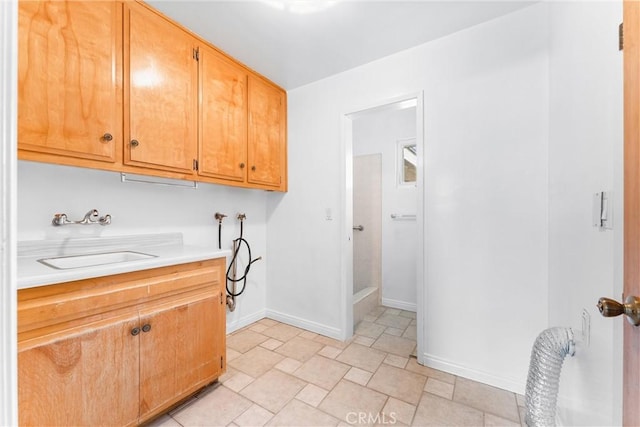 washroom featuring sink, hookup for a washing machine, and cabinets