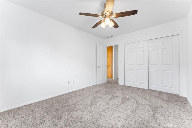 unfurnished bedroom featuring ceiling fan, a closet, and carpet flooring