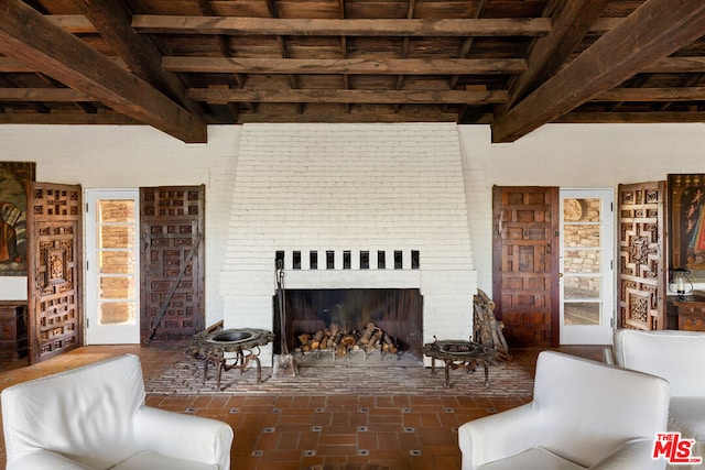 living room with vaulted ceiling with beams, wood ceiling, and a fireplace