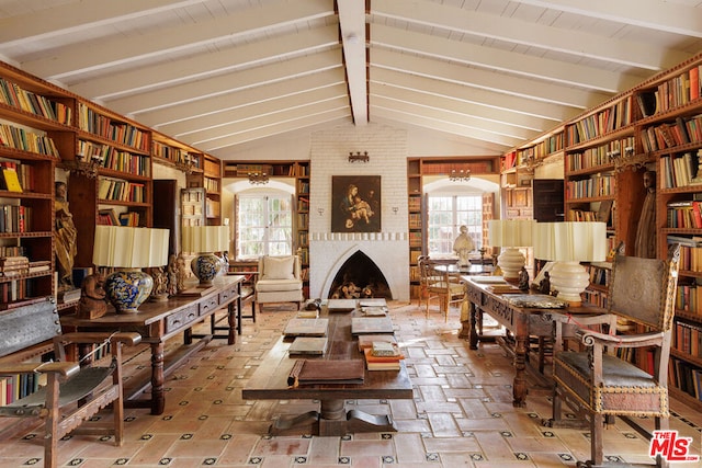 living area with lofted ceiling with beams, plenty of natural light, and a fireplace