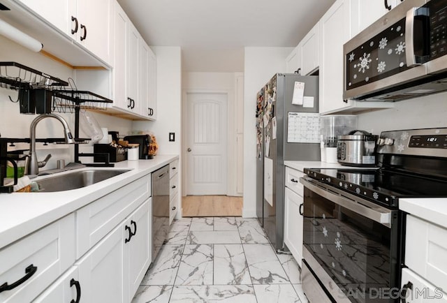 kitchen featuring sink, stainless steel appliances, and white cabinetry