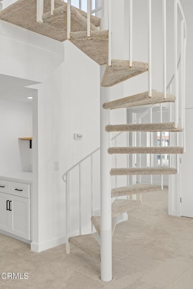 stairs featuring baseboards and carpet floors