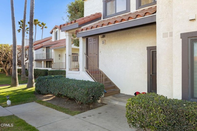 property entrance featuring stucco siding and a tile roof