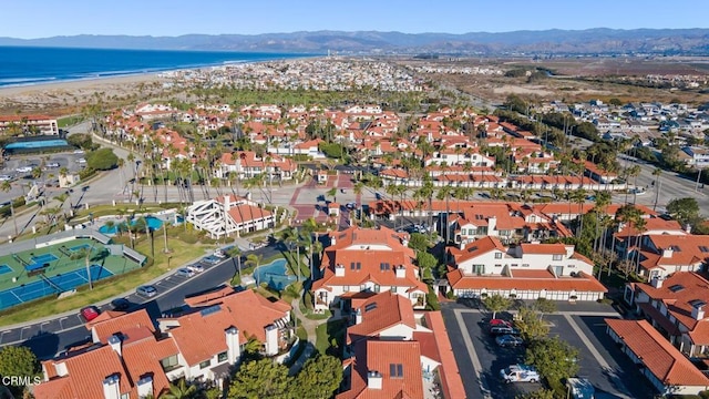 aerial view featuring a residential view, a water and mountain view, and a beach view