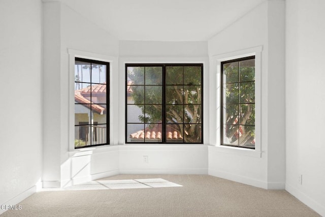 unfurnished room featuring vaulted ceiling, baseboards, and carpet floors