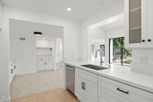 kitchen featuring visible vents, a sink, light countertops, glass insert cabinets, and dishwasher