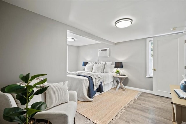 bedroom featuring a wall mounted air conditioner and light wood-type flooring