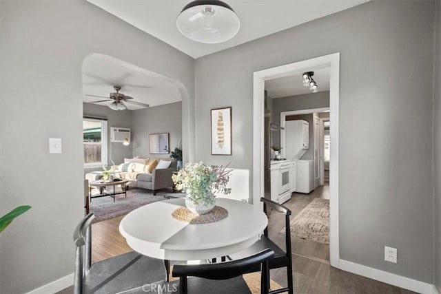 dining space with ceiling fan, hardwood / wood-style flooring, and a wall mounted air conditioner