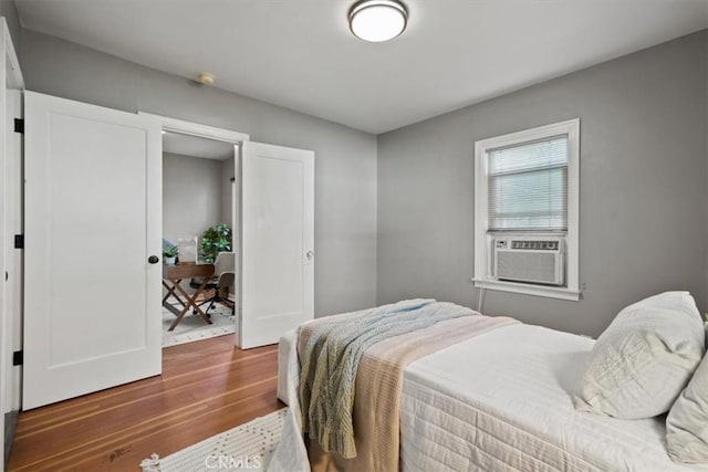 bedroom with cooling unit and hardwood / wood-style floors