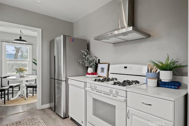 kitchen with white cabinets, wall chimney range hood, and white appliances