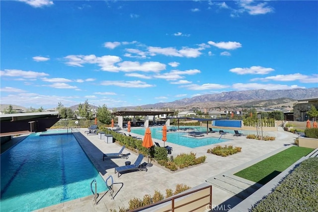 view of pool with a mountain view and a patio